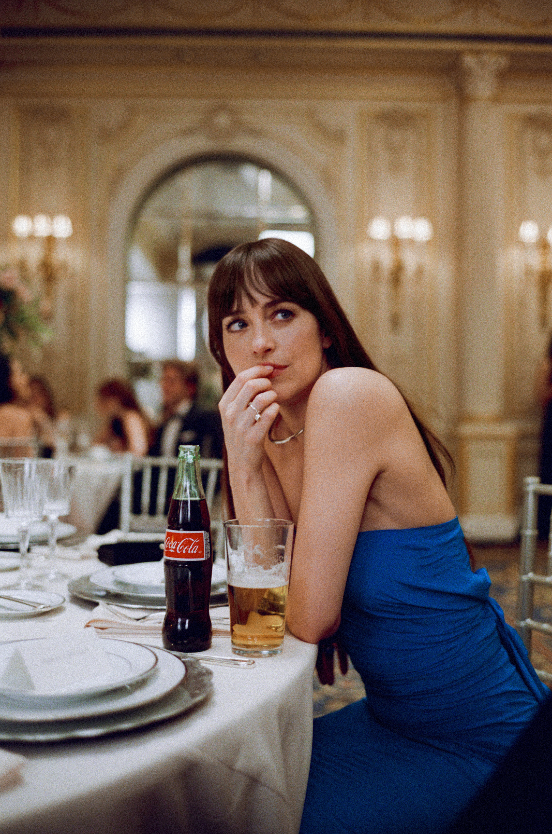 dakota johnson wearing a blue formal gown at a wedding drinking coke and beer in the movie materialists