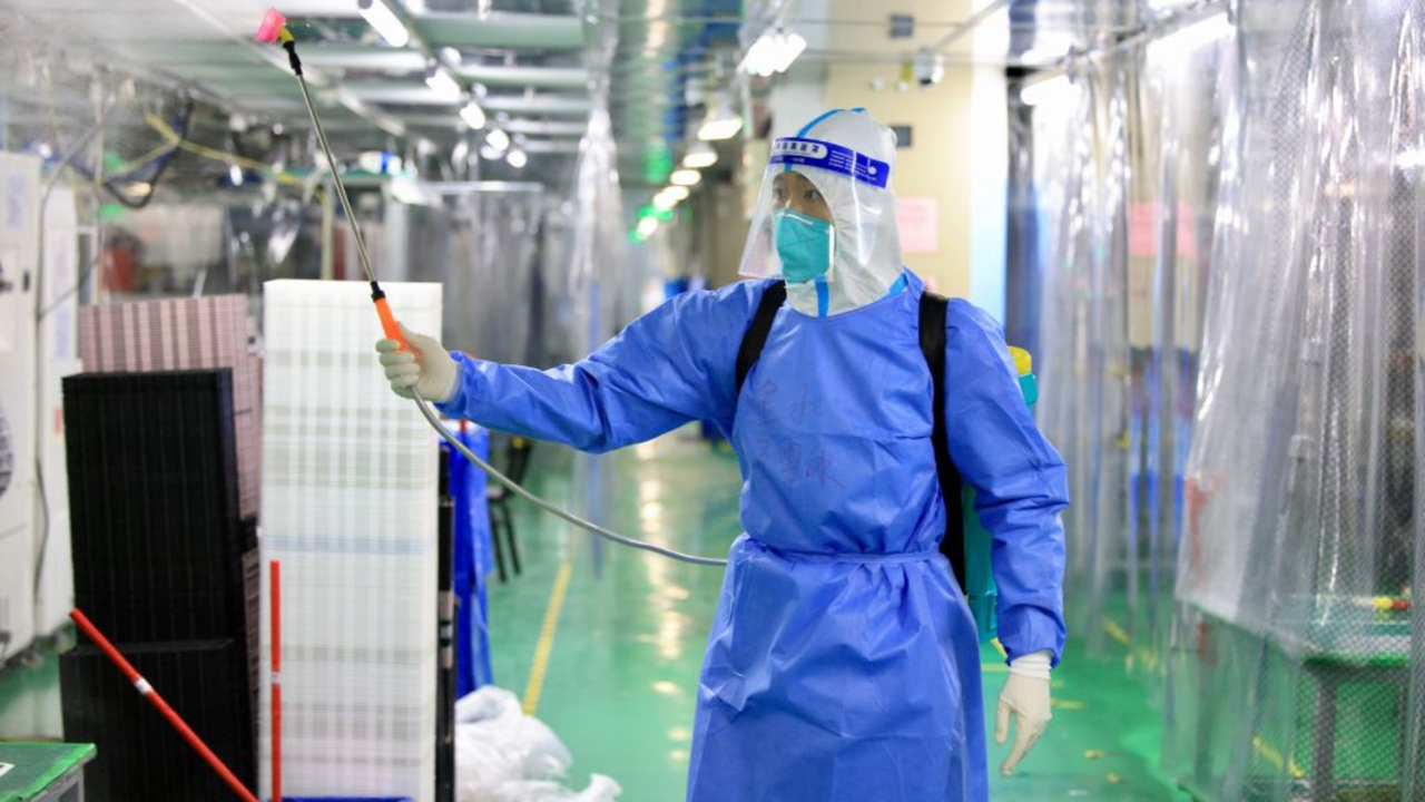 A staff member sprays disinfectant at a Foxconn factory in Zhengzhou