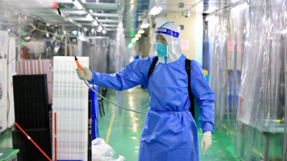 A staff member sprays disinfectant at a Foxconn factory in Zhengzhou