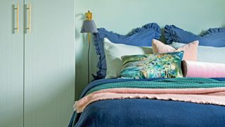 soothing sage green bedroom color scheme with navy bedding