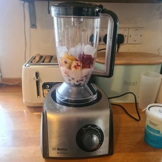 The Bosch MultiTalent 8 food processor on a kitchen counter - the mixing jug filled with fresh fruit and ice cubes.