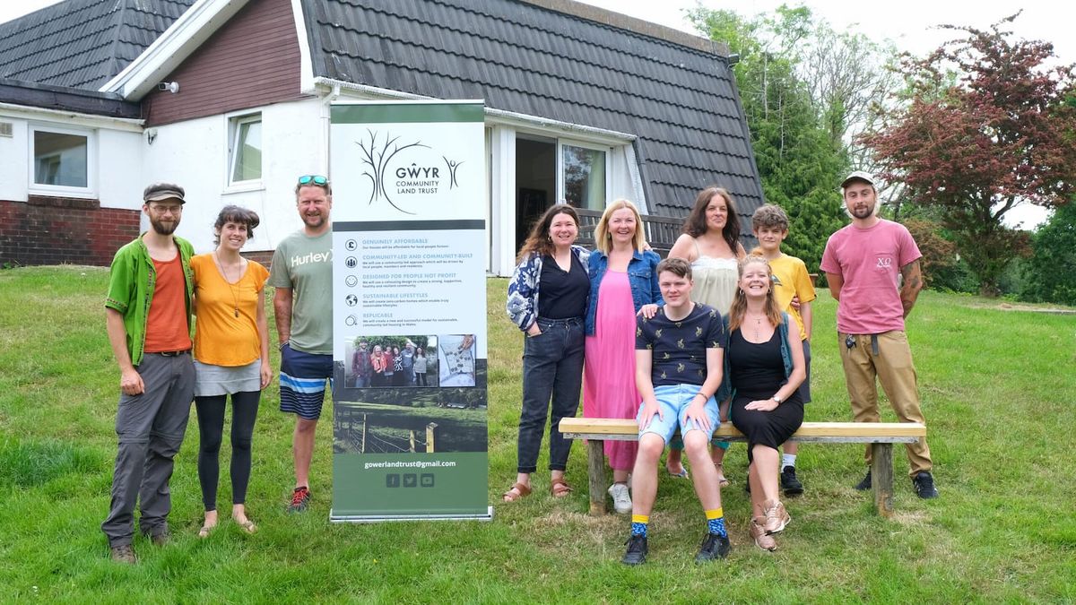 A group of self builders stood next to a poster