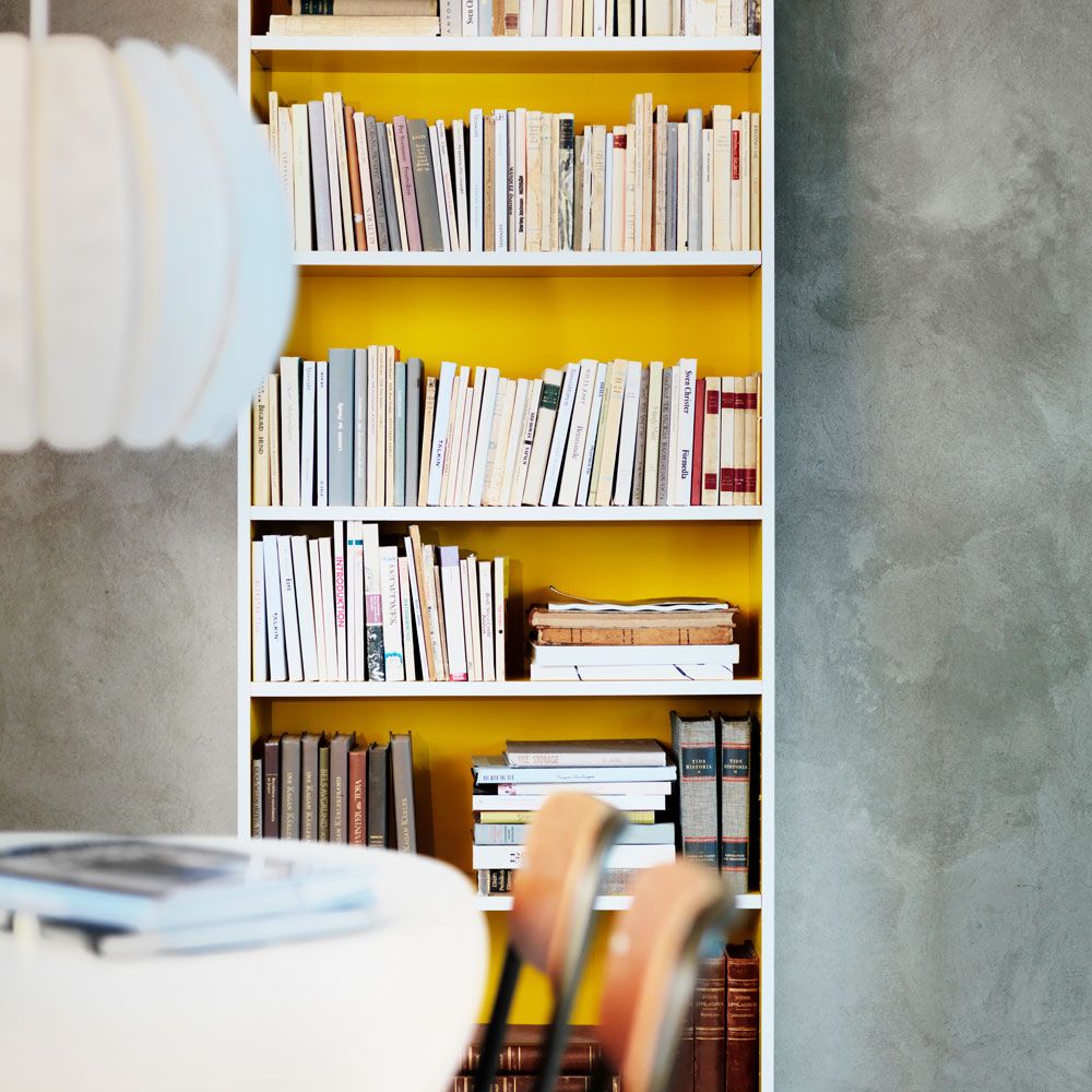 room with grey wall and books in book shelves