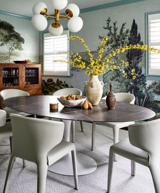 dining room with tree mural wall and white dining chairs