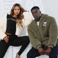 A male and female model wearing outfits from True Religion.