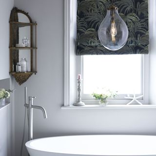 bathroom with white wall white bathtub and hanging light