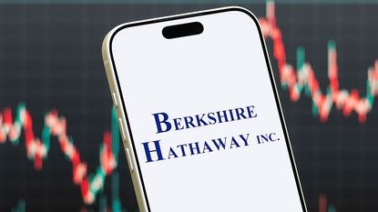 Berkshire Hathaway log on a smartphone with a blurred stock chart in the background