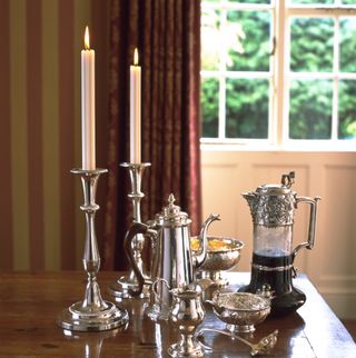 Silver candlesticks and coffee pot on a table