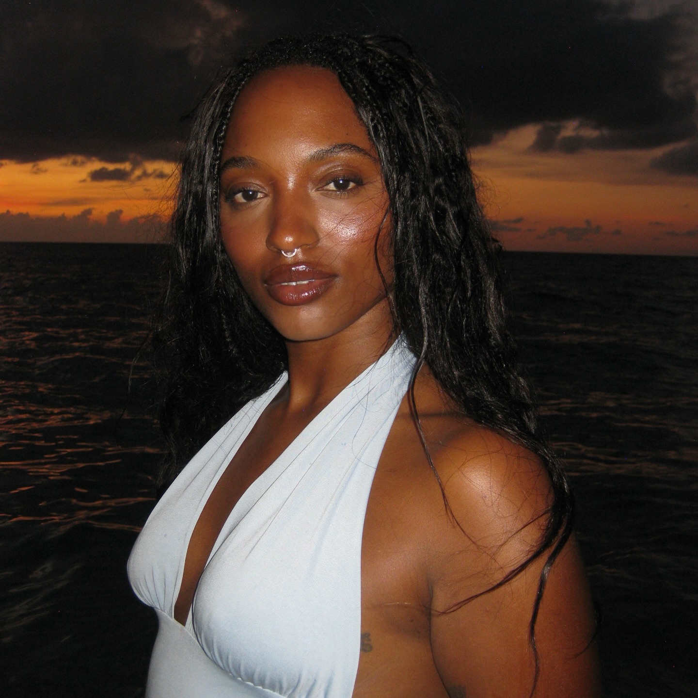 An image of a woman on the beach with glowing skin.