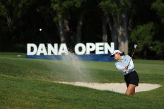 Rose Zhang hits a bunker shot in front of a Dana Open sign