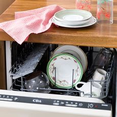 wooden dishwasher with white plates and glasses