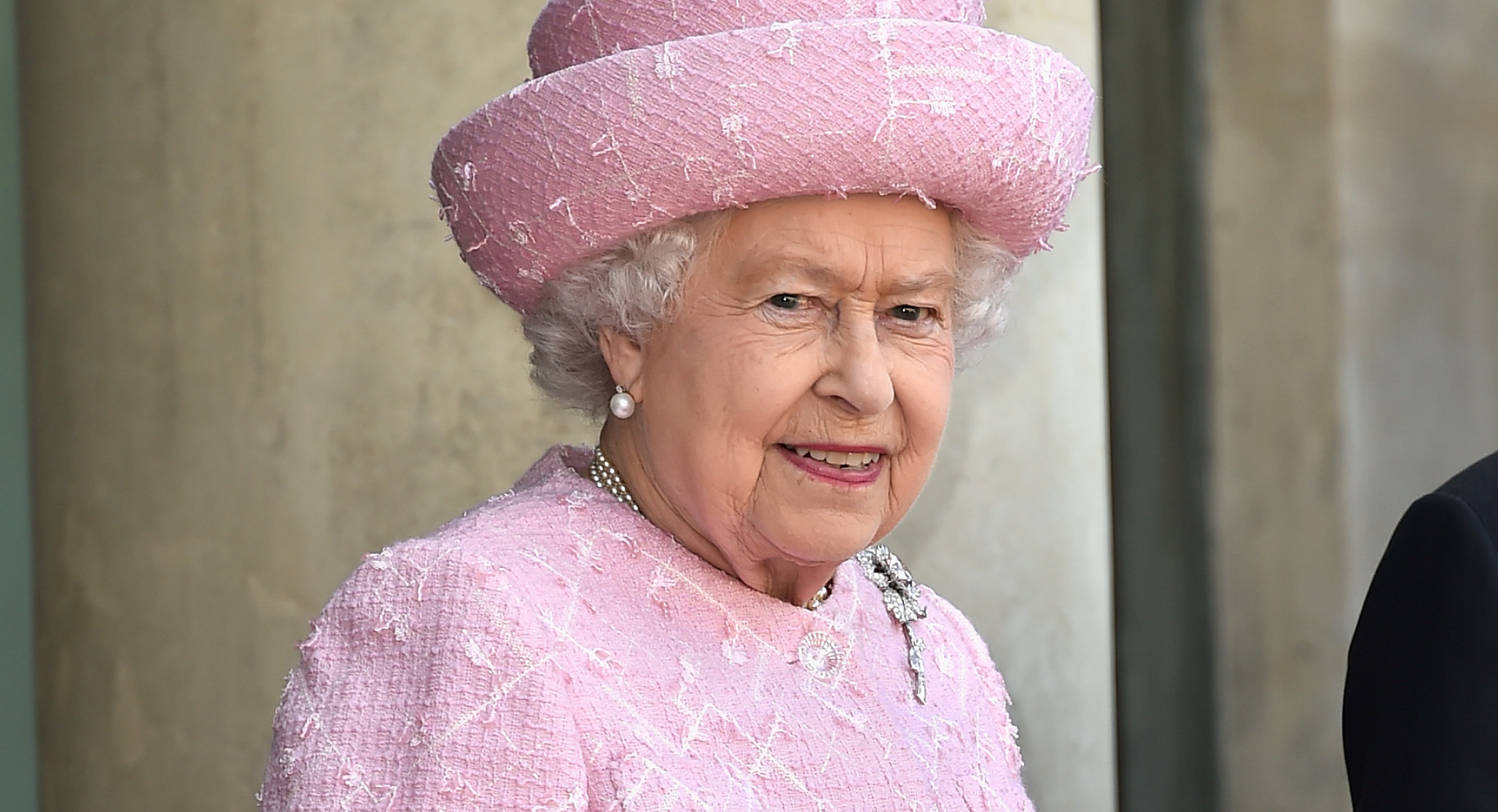 Queen Elizabeth wears a bubblegum pink suit and matching hat