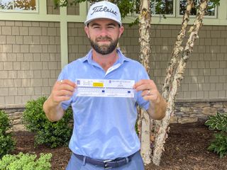 Cameron Young holds up his 59 scorecard at the Travelers Championship