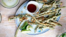 Overhead shot of asparagus with honey on a blue plate