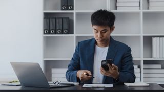 Asian businessman working online with laptop at desk in office, Working businessman lifestyle concept.