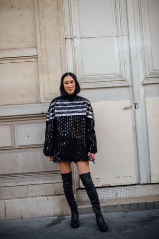 Eva Chen wearing black thigh high boots and a black and silver sequined sweater dress