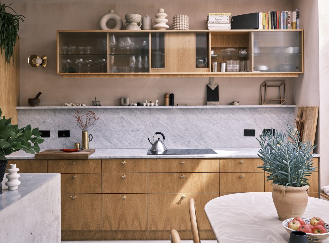 A modern kitchen with wooden cabinetry and stoneware vases displayed on top