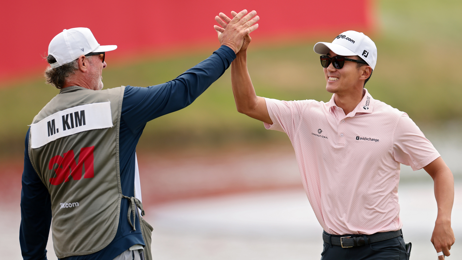 Michael Kim high fives his caddie
