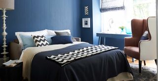 dark blue bedroom showing color drenching as a way to make a bedroom look expensive