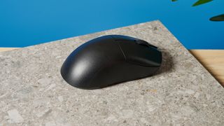 A black Lemokey G1 wireless gaming mouse sitting on a marble slab