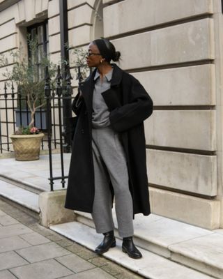 @_livmadeline wearing a grey trouser and top set with long black coat