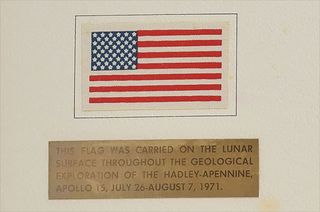 A fabric American flag with a small plaque under it explaining its origin.