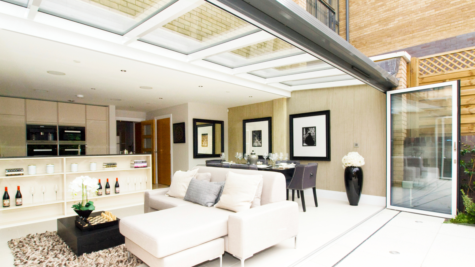 living room extension with bifold doors and roof featuring glazed panels along the full width of the room