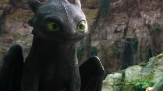 Toothless sits patiently and waitingly as he looks on at Hiccup in the live-action adaptation of How to Train Your Dragon (2025). 