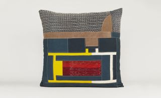 Blue cushion with red, yellow, brown, and patterned patches