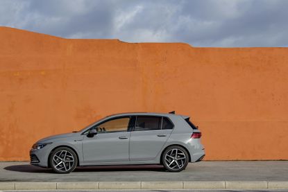 The eighth generation Volkswagen Golf against a red wall