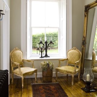 hallway with wooden flooring and elegant chairs