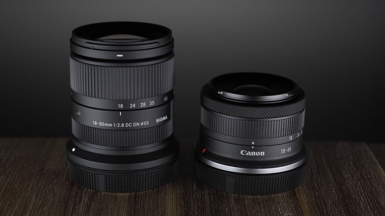 The Sigma 18-50mm f/2.8 DC DN | C Canon RF lens on a wooden surface against a dark background with moody lighting