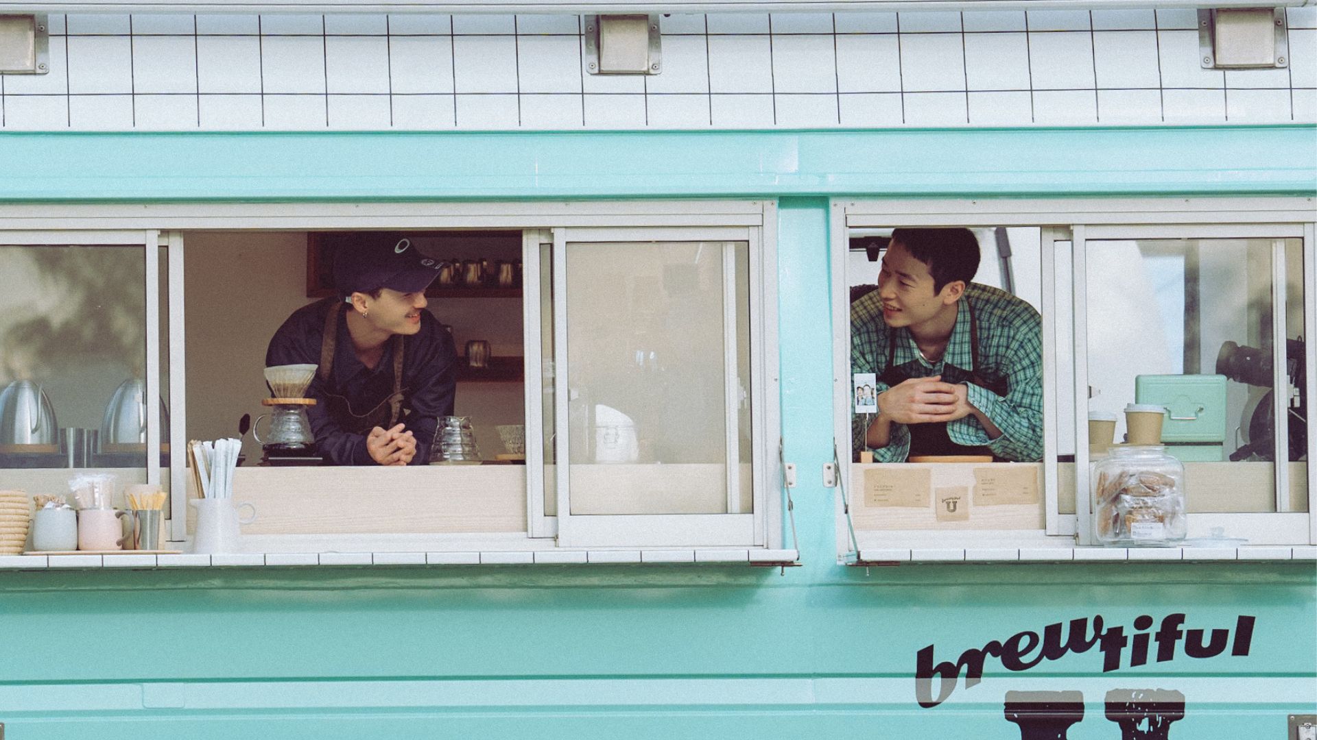 Two men look at each other in a coffee van