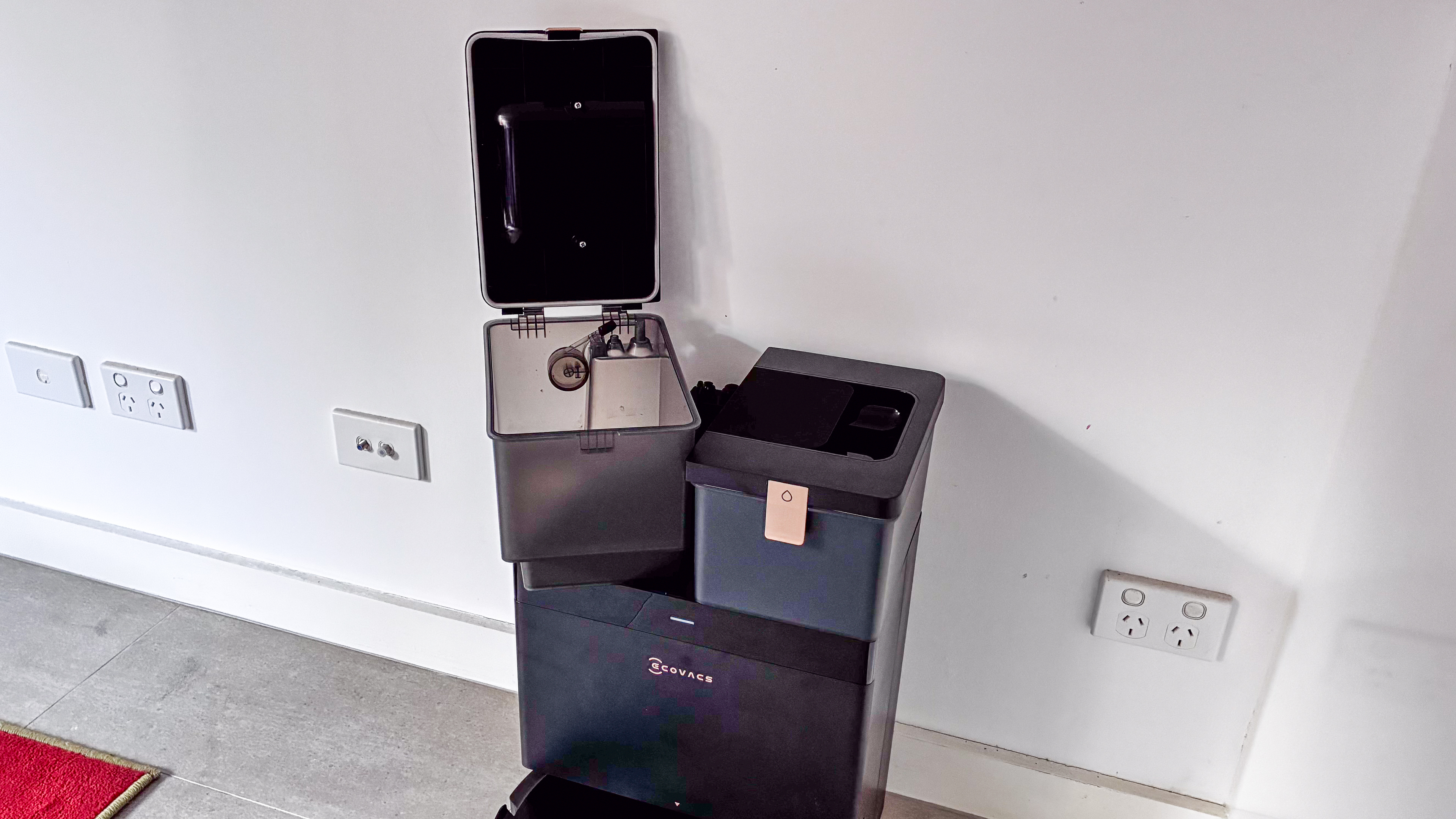 The dirty-water tank standing open atop the Ecovacs Deebot X8 Pro Omni base station