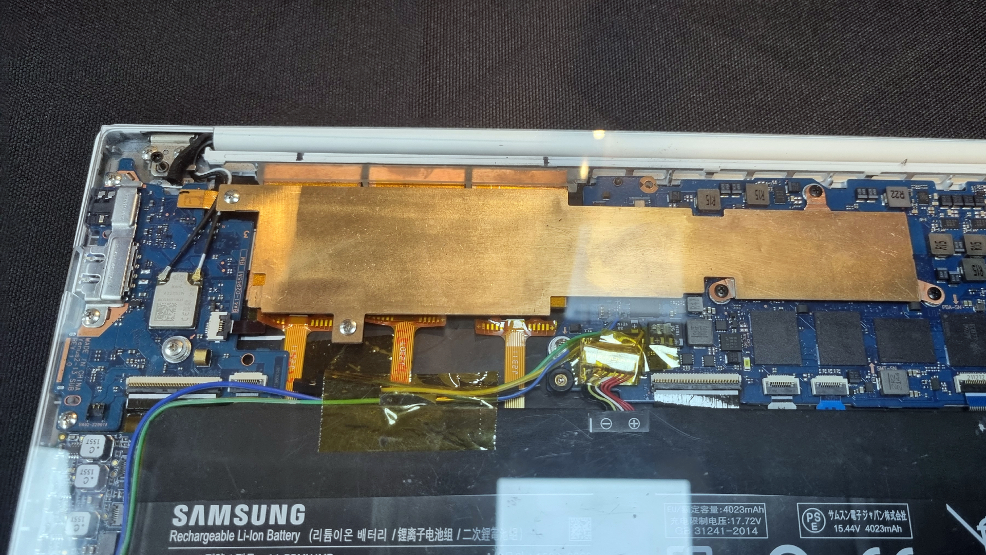 A Samsung laptop with a transparent panel, showing several Frore AirJet Mini Slims sitting underneath a copper plate
