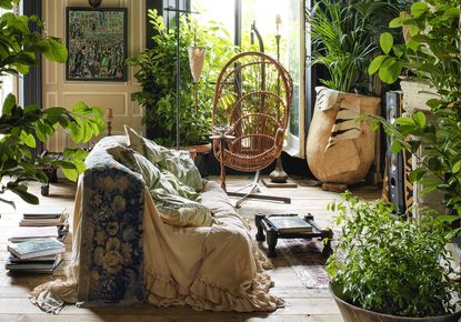 boho living room with lots of house plants and a white sofa