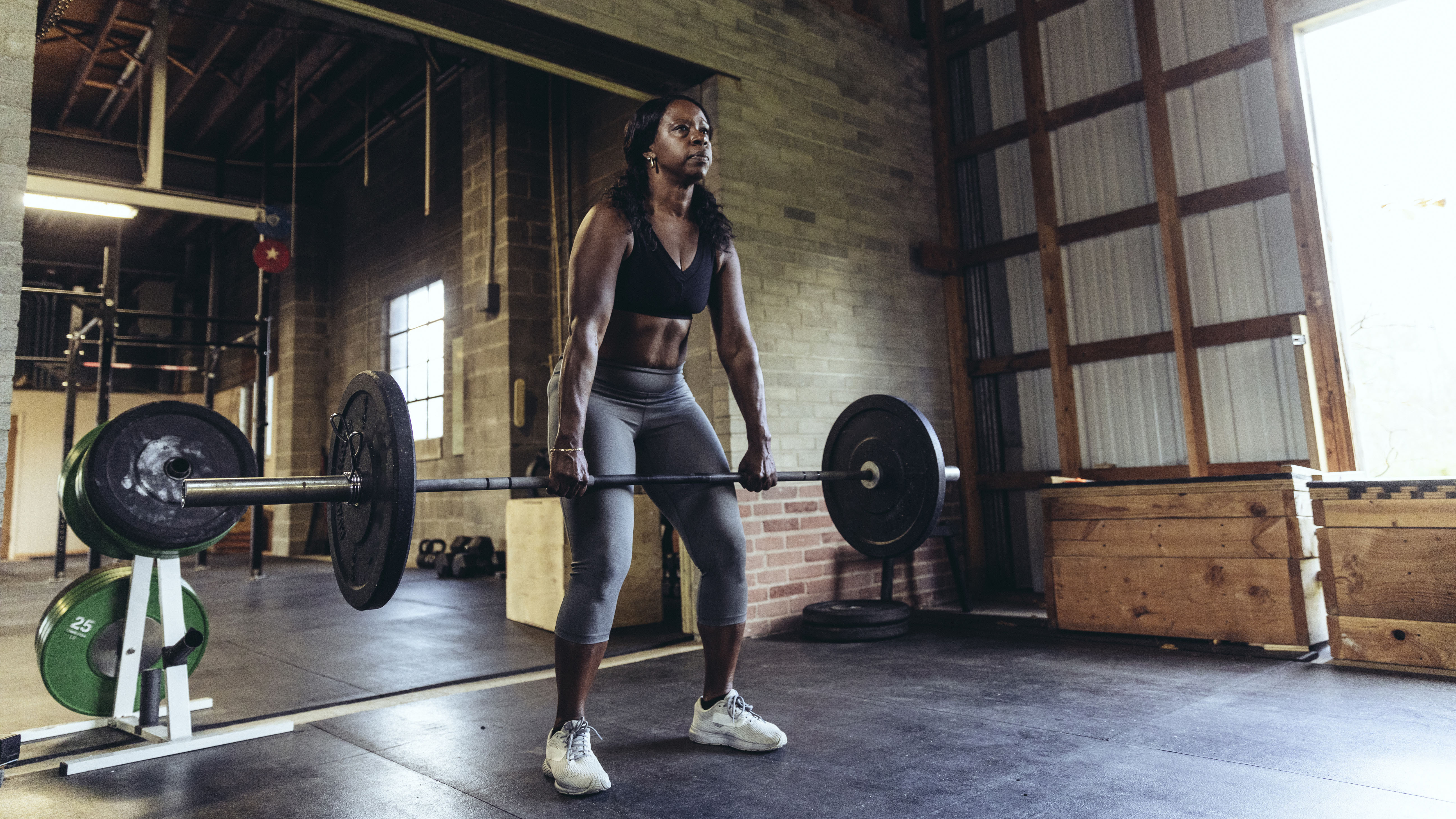 Woman performing deadlift to activate gluteal muscles