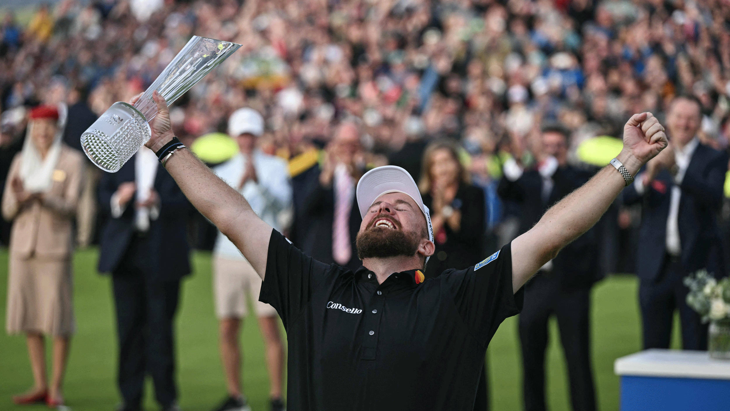 Shane Lowry puts both arms outstretched while holding the Irish Open trophy in 2026