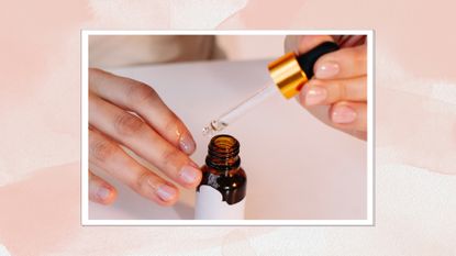 A close up of someone applying cuticle oil to their nails, which feature a glossy, natural-looking manicure/ in a pink watercolour paint-style template 
