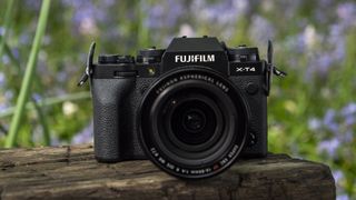 Fujifilm X-T4 placerad på en träbänk med den nya 16-80 mm kitlinsen.