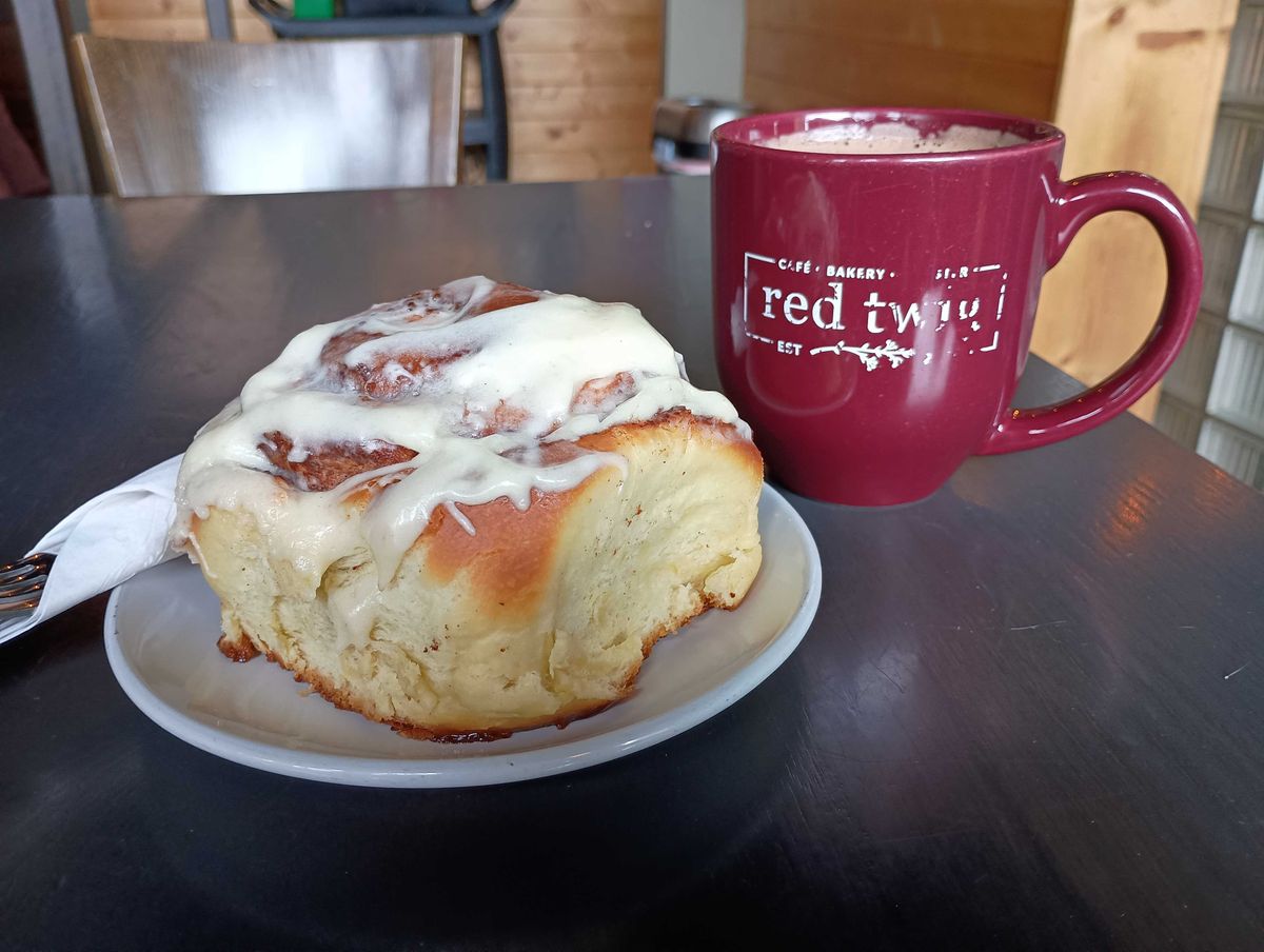 A cinnamon roll and coffee mug
