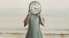 Woman holding clock in front of her face