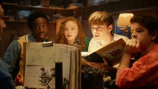Lucas, Max, Will, and Dustin looking at Mike while playing Dungeons and Dragons.