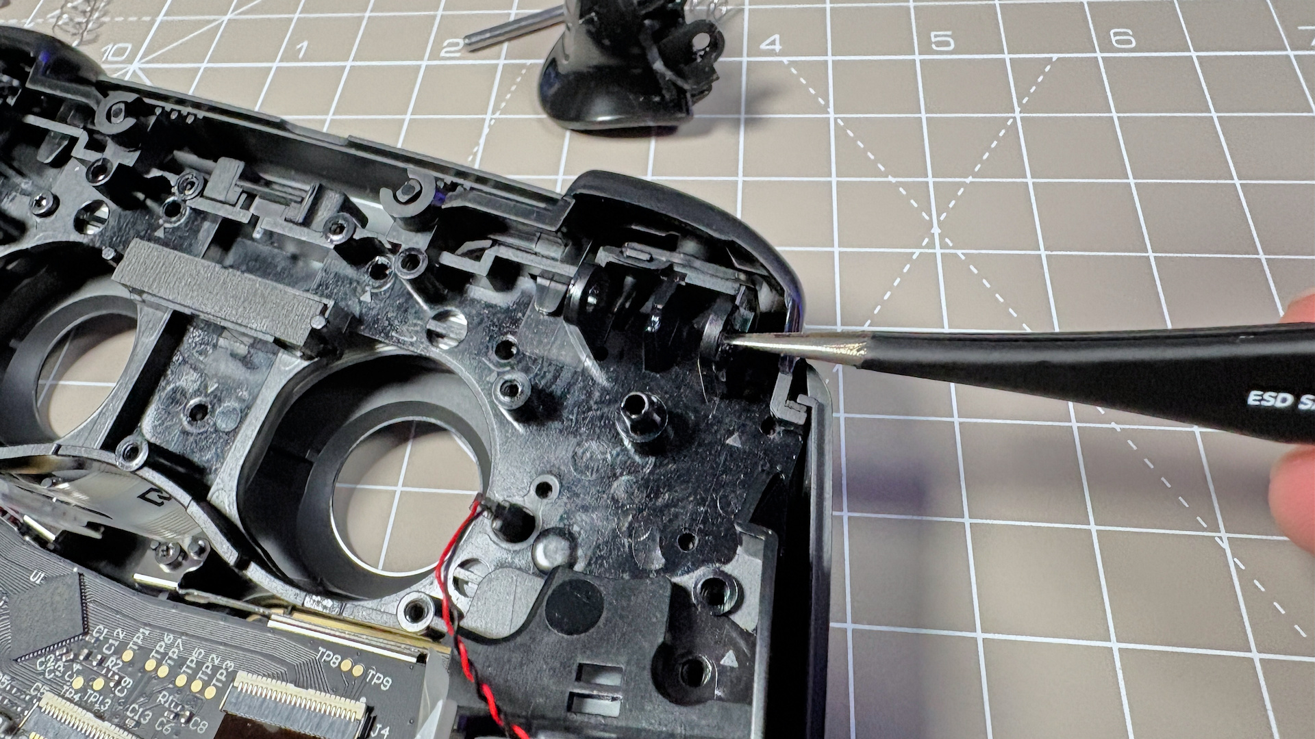 The Steam Controller on a desk during a teardown, with various parts removed.