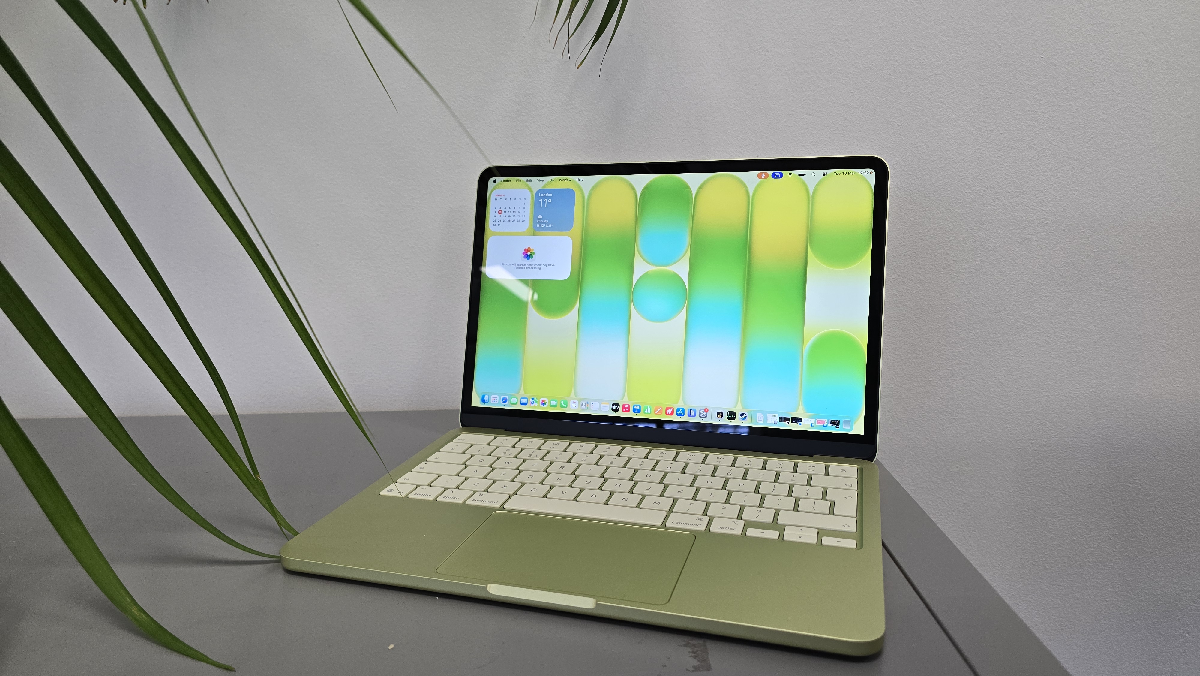 MacBook Neo laptop on a desk with plant in background