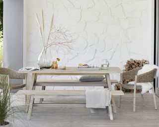 White wooden Scandinavian bench dining area in a covered porch area by John Lewis & Partners