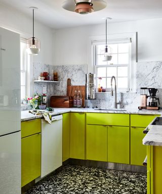 small kitchen with bright green cabinets and marble surfaces