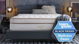 The Saatva Classic mattress photographed on a fabric bed frame with a Black Friday mattress deals badge overlaid on the image