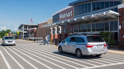 Cars pass in front of a Walmart entrance