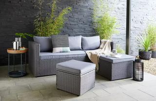 A compact rattan garden sofa with chaise